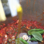 Gutes Olivenöl bei der Tomatensoße hinzugeben